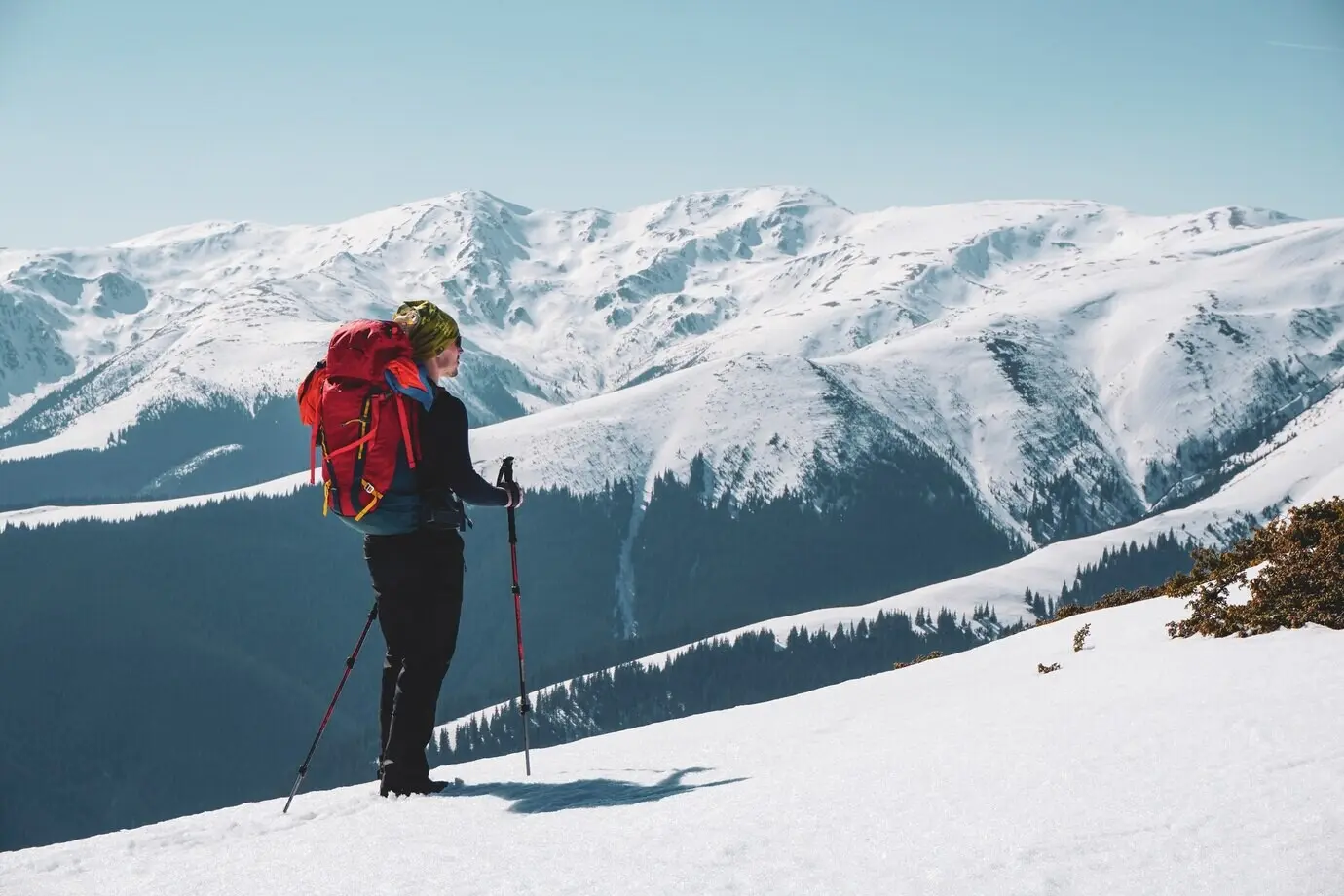 Male mountaineer taking in the snow-covered mountain view from the summit